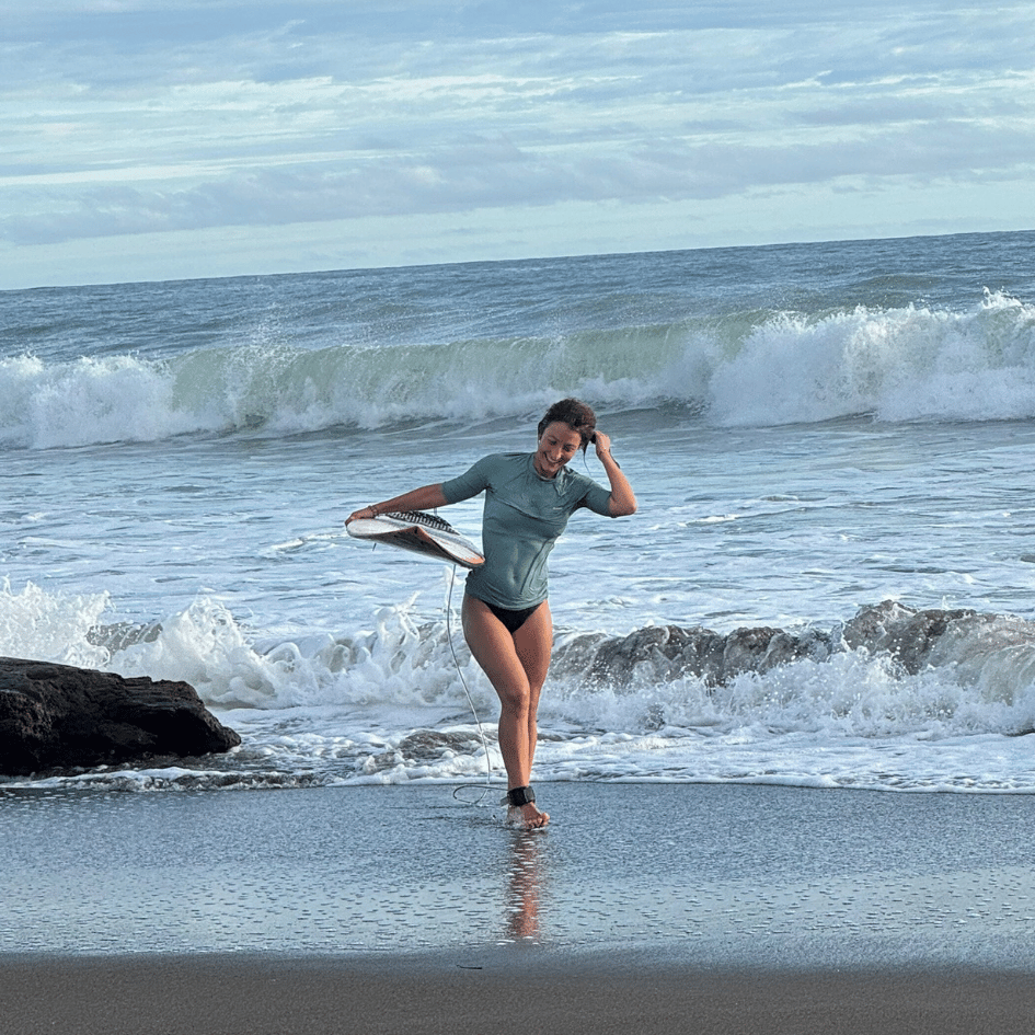 Surfeuse sortant de l'eau sur la plage d'El Almejal